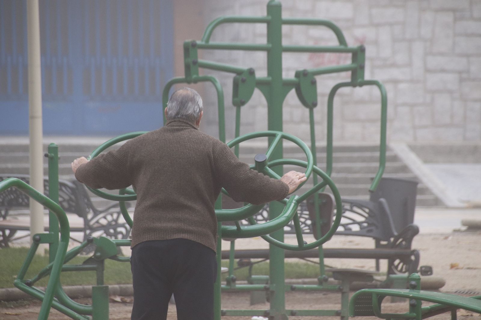 Señor mayor en el parque de la Alamedilla haciendo deporte en invierno con frío.