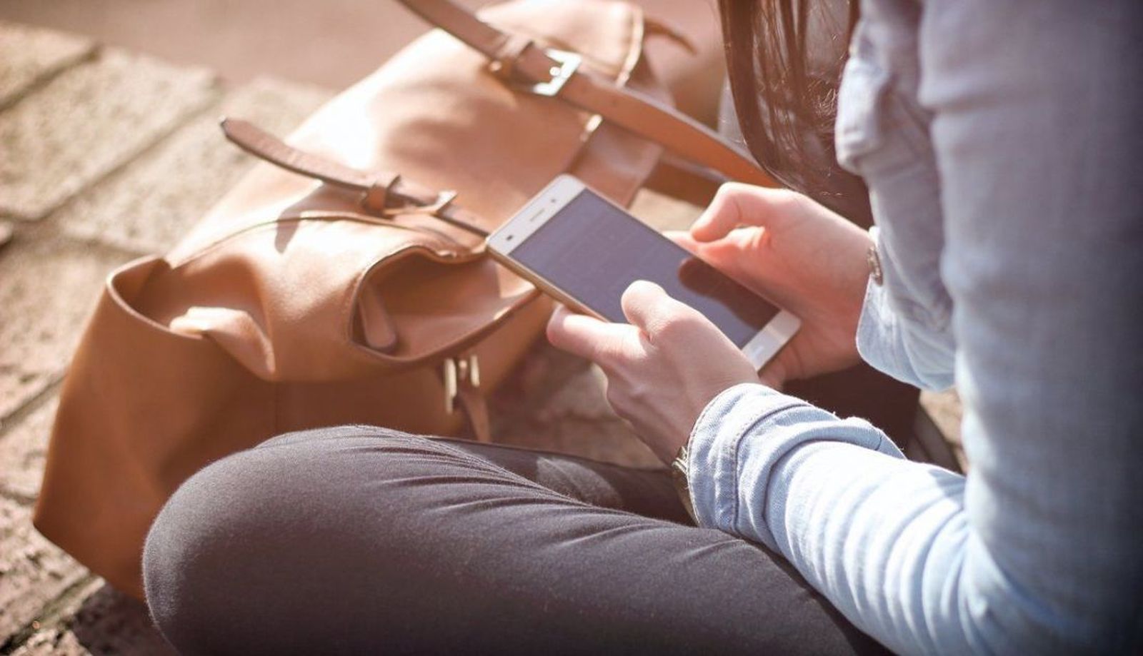 Una persona sentada mirando el teléfono móvil. EP Una persona sentada mirando el teléfono móvil. EP
