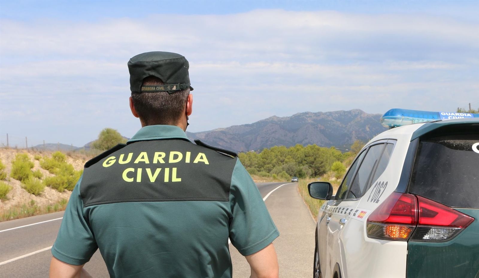 Un agente de la Guardia Civil junto a un vehículo en una carretera. FOTO GUARDIA CIVIL EP