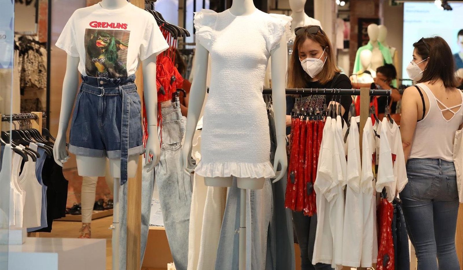 Personas con mascarilla en el interior de una tienda de ropa EP