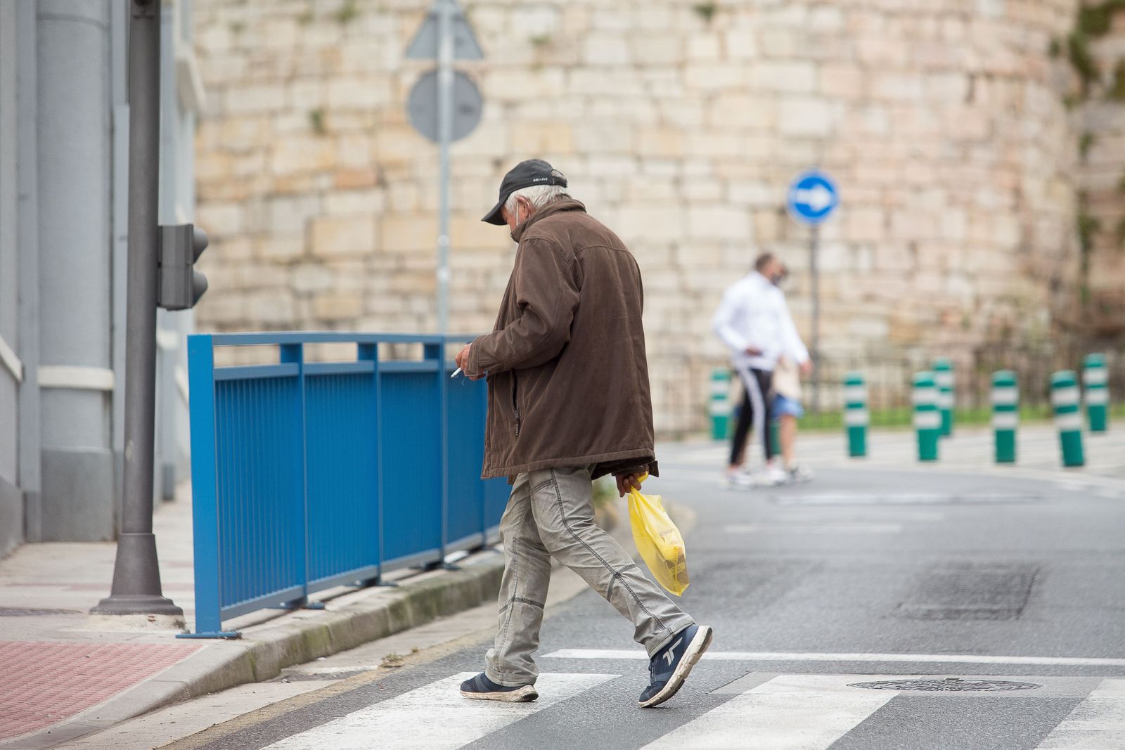Una persona fuma durante el primer día de la prohibición de realizarlo en la vía pública en Galicia si no existe una distancia de dos metros de separación con otras personas para evitar contagios Una persona fuma durante el primer día de la prohibición de realizarlo en la vía pública en Galicia si no existe una distancia de dos metros de separación con otras personas para evitar contagios