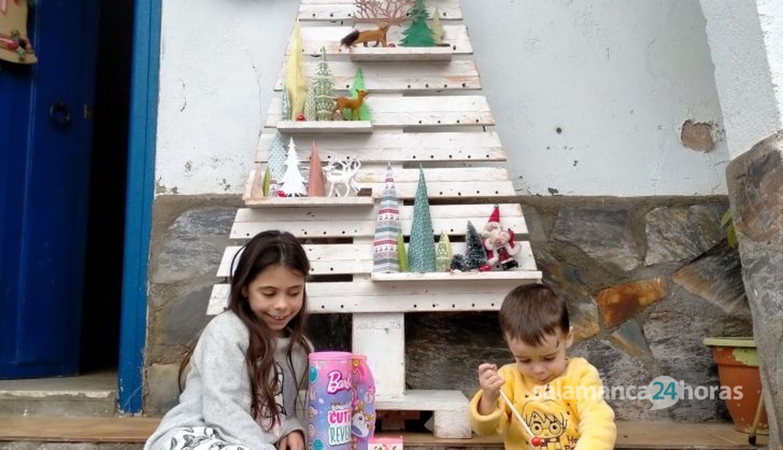 Triana y Mario posan junto a los juguetes que les ha dejado Papá Noel
