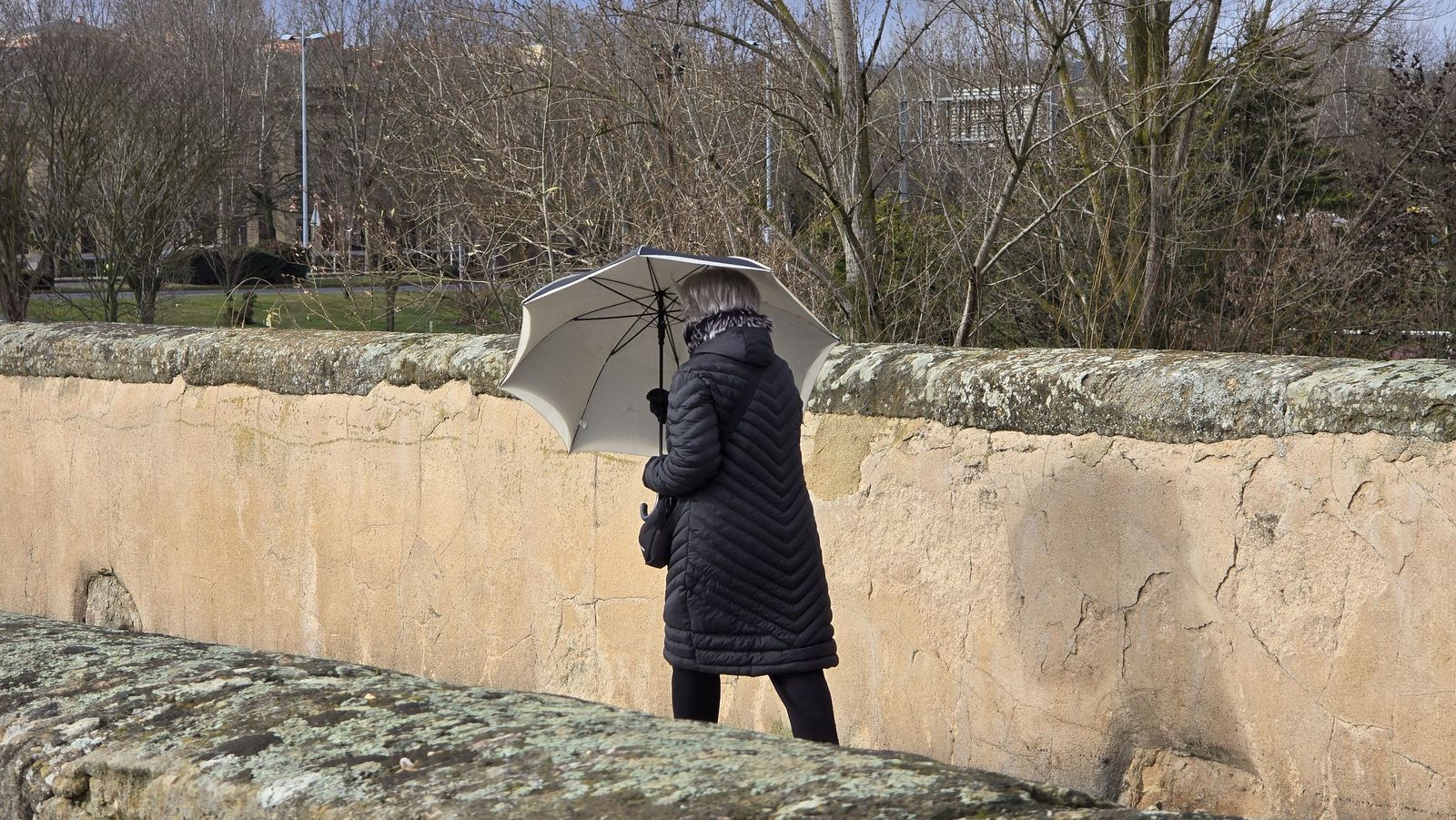 Mujer paseando con paraguas por el Puente Romano