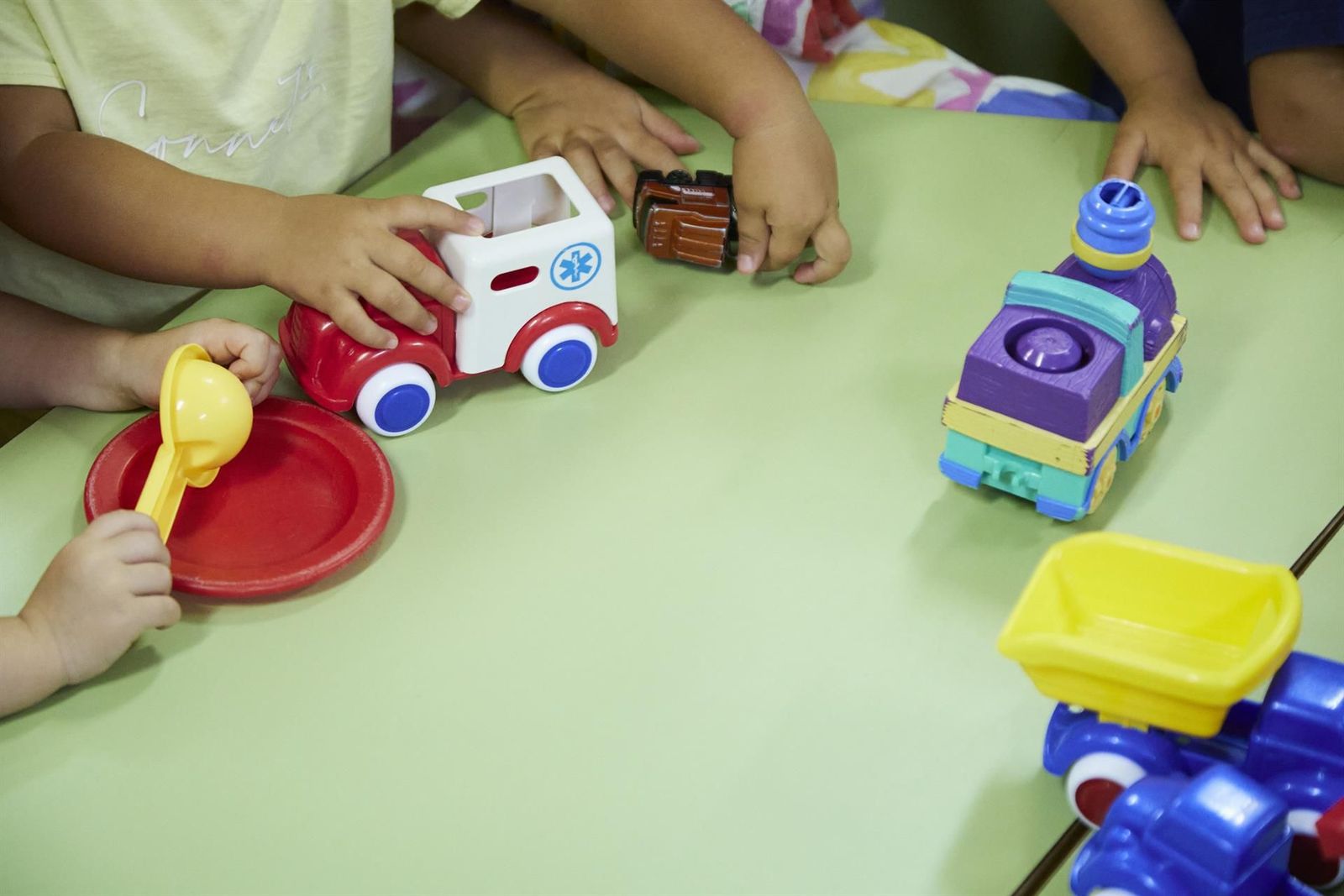Detalles de unos niños jugando en una mesa Detalles de unos niños jugando en una mesa