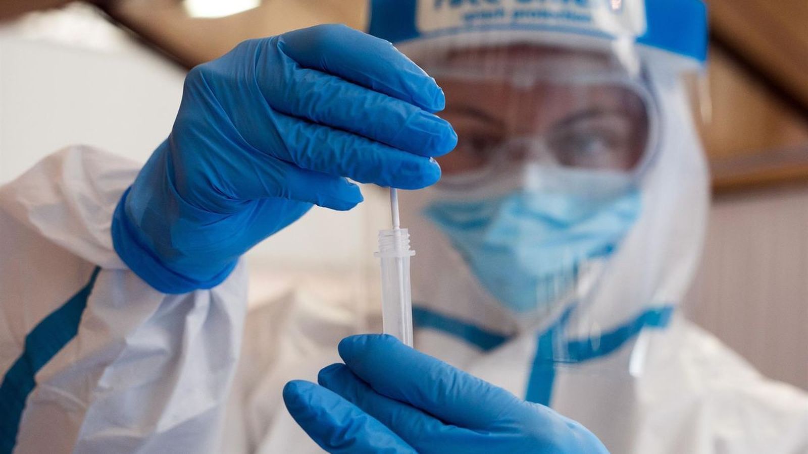 Una trabajadora sanitaria protegida muestra uno de los test de antígenos. | FOTO: EUROPA PRESS