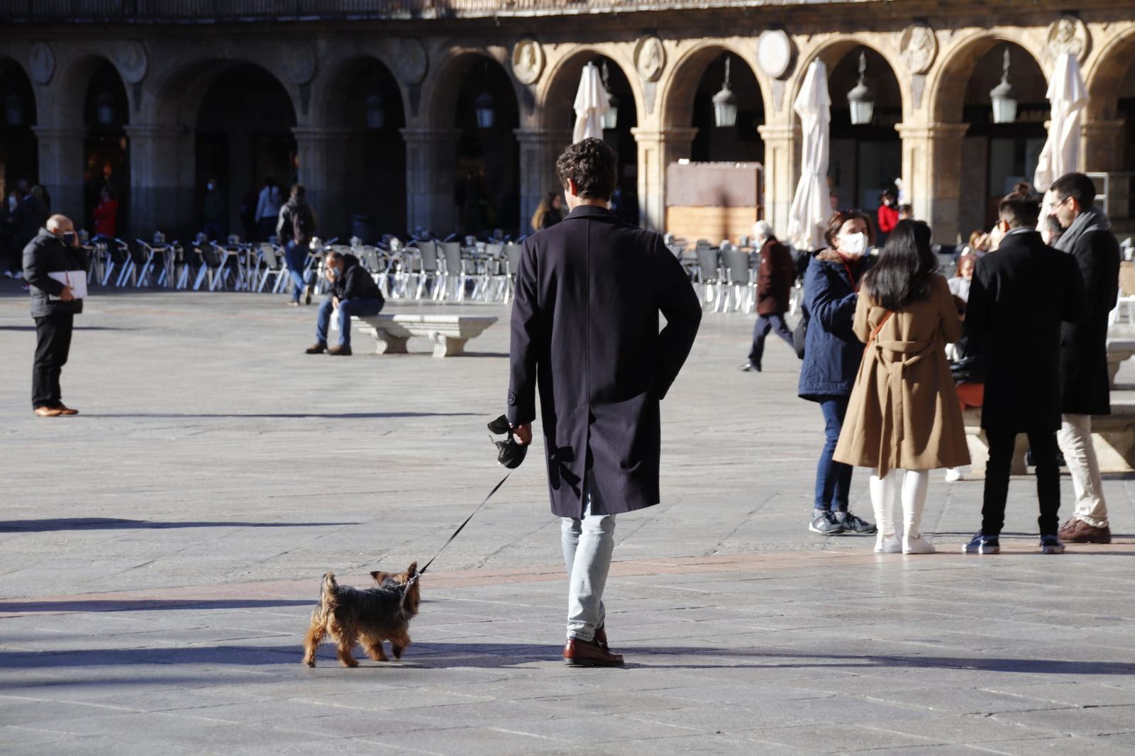 Chico paseando a su perro en la Plaza Mayor | Foto archivo Chico paseando a su perro en la Plaza Mayor | Foto archivo