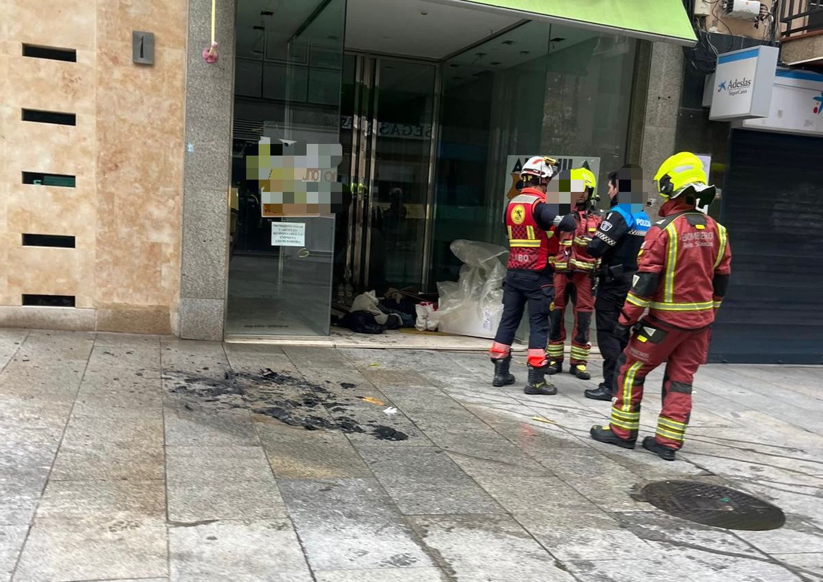 Los bomberos sofocan un incendio con papeles y cartones en un portal de la calle Arco