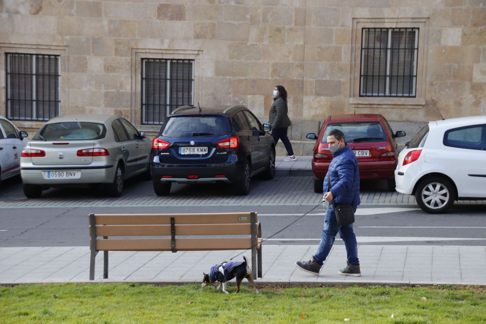 Señor paseando a su perro en invierno