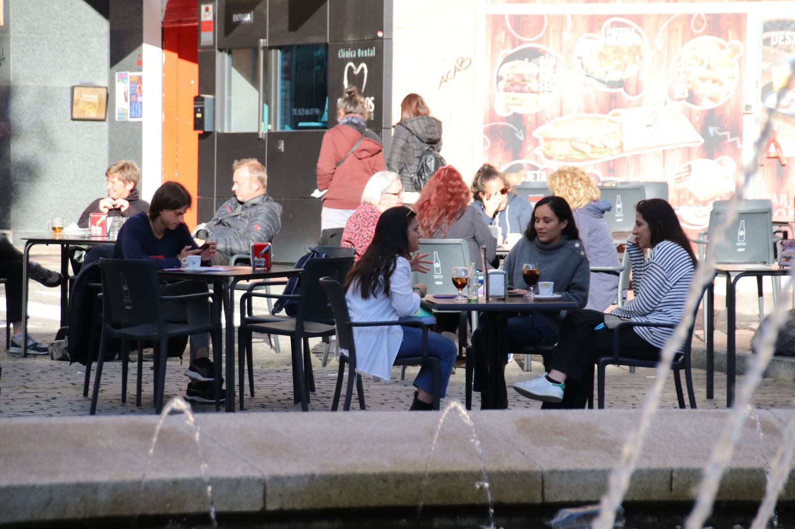 Terraza con gente en la Plaza del Oeste, otoño