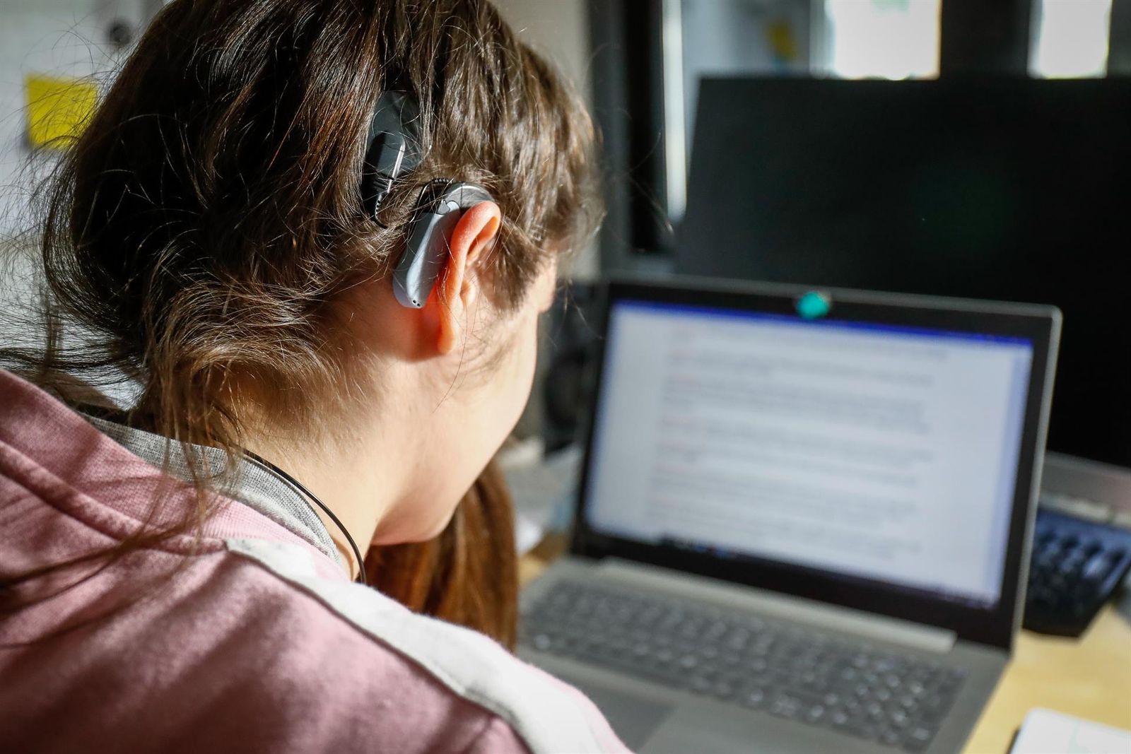 Una joven usuaria de audífonos estudiando