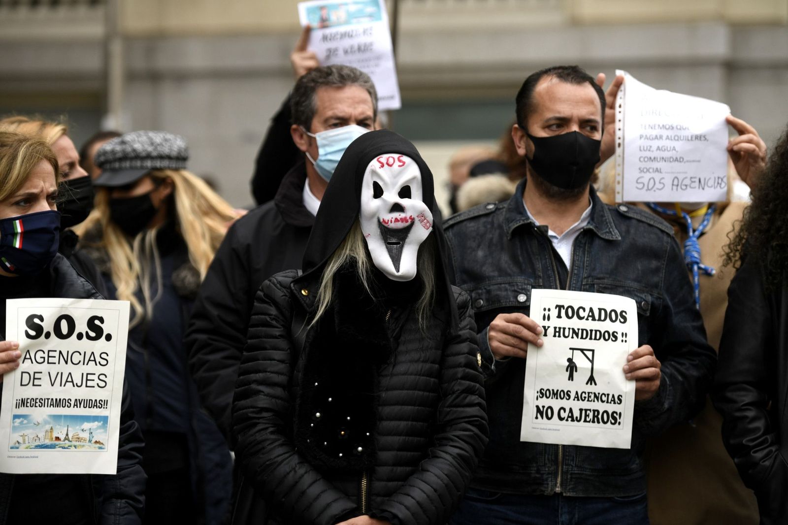 Trabajadores del sector de las agencias se concentran con caretas similares a la del film 'Scary movie' y carteles reivindicativos frente al Congreso de los Diputados, en Madrid (España), a 18 de nov