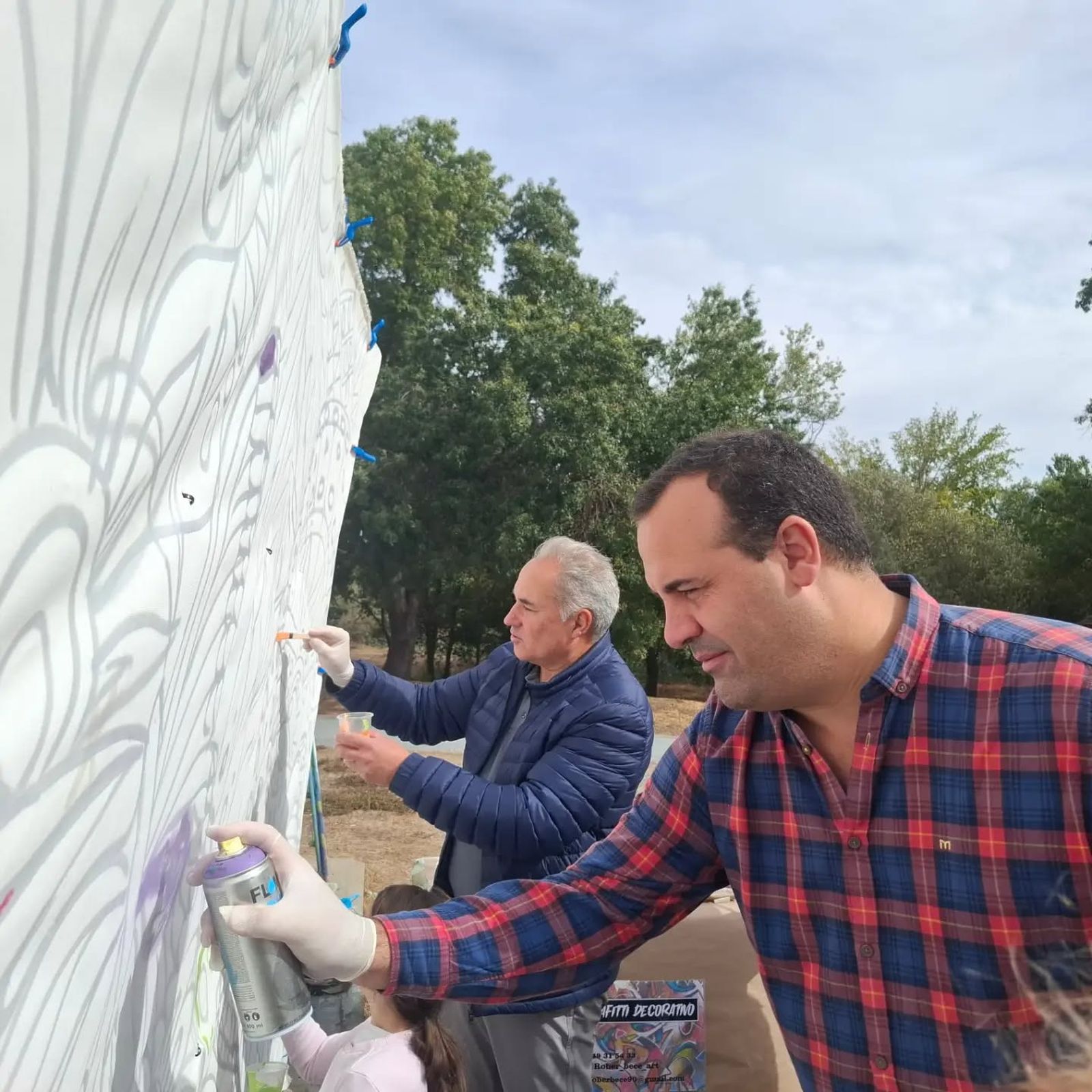 Ángel Losada y David Mingo pintando un mural con motivo del Día de las Familias en la Isla del Soto