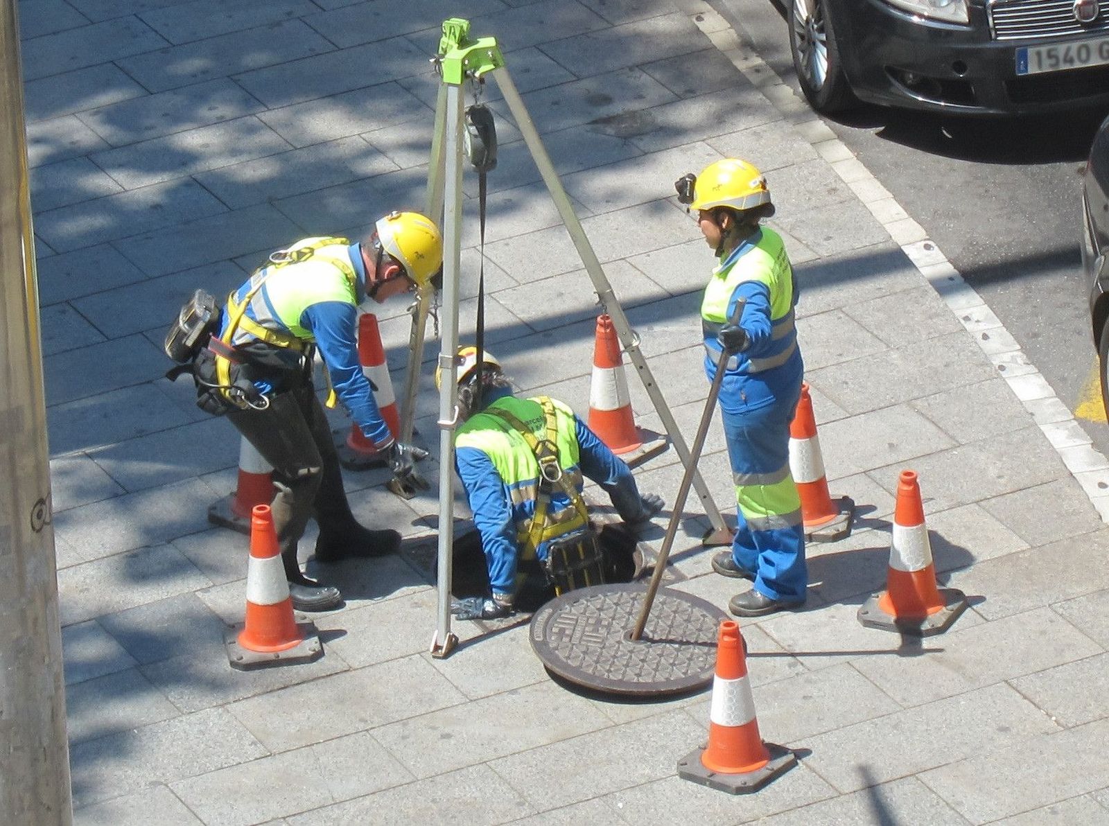 Seguridad en el trabajo, seguridad laboral, obreros con casco y chaleco reflectante, obra señalizada con conos, alcantarillado Seguridad en el trabajo, seguridad laboral, obreros con casco y chaleco reflectante, obra señalizada con conos, alcantarillado