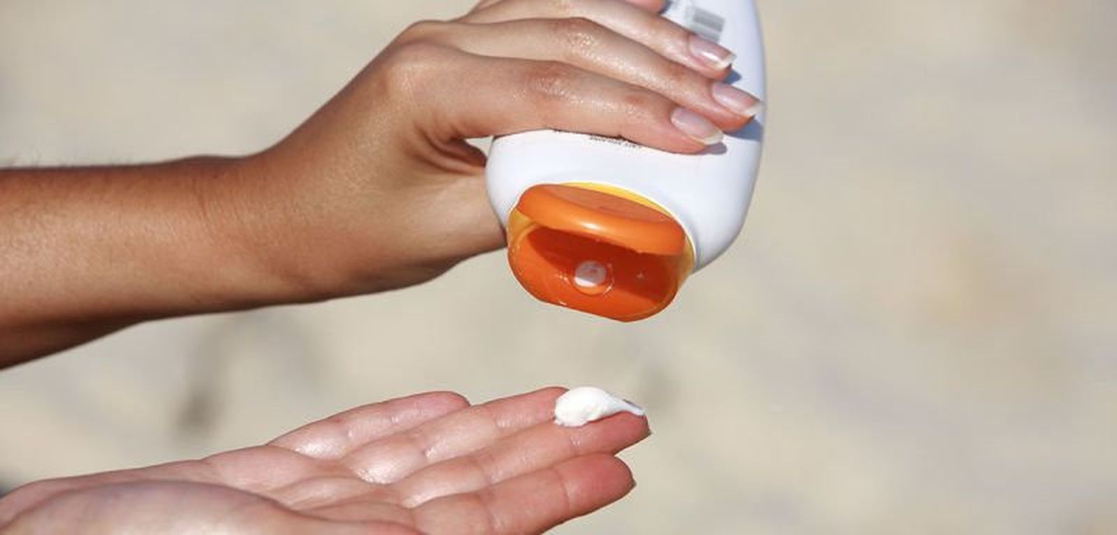 Una mujer se dispone a aplicar fotoprotector solar contra el sol