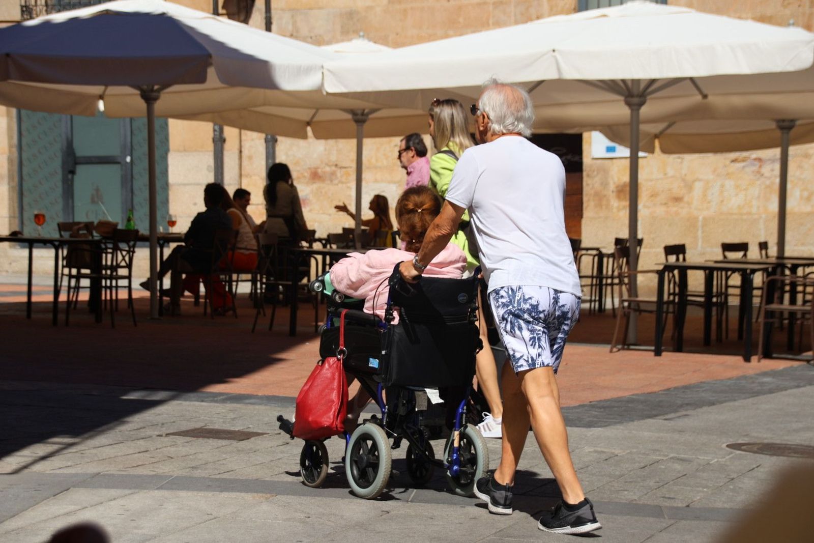 Gente paseando por Salamanca en silla de ruedas. Foto de archivo