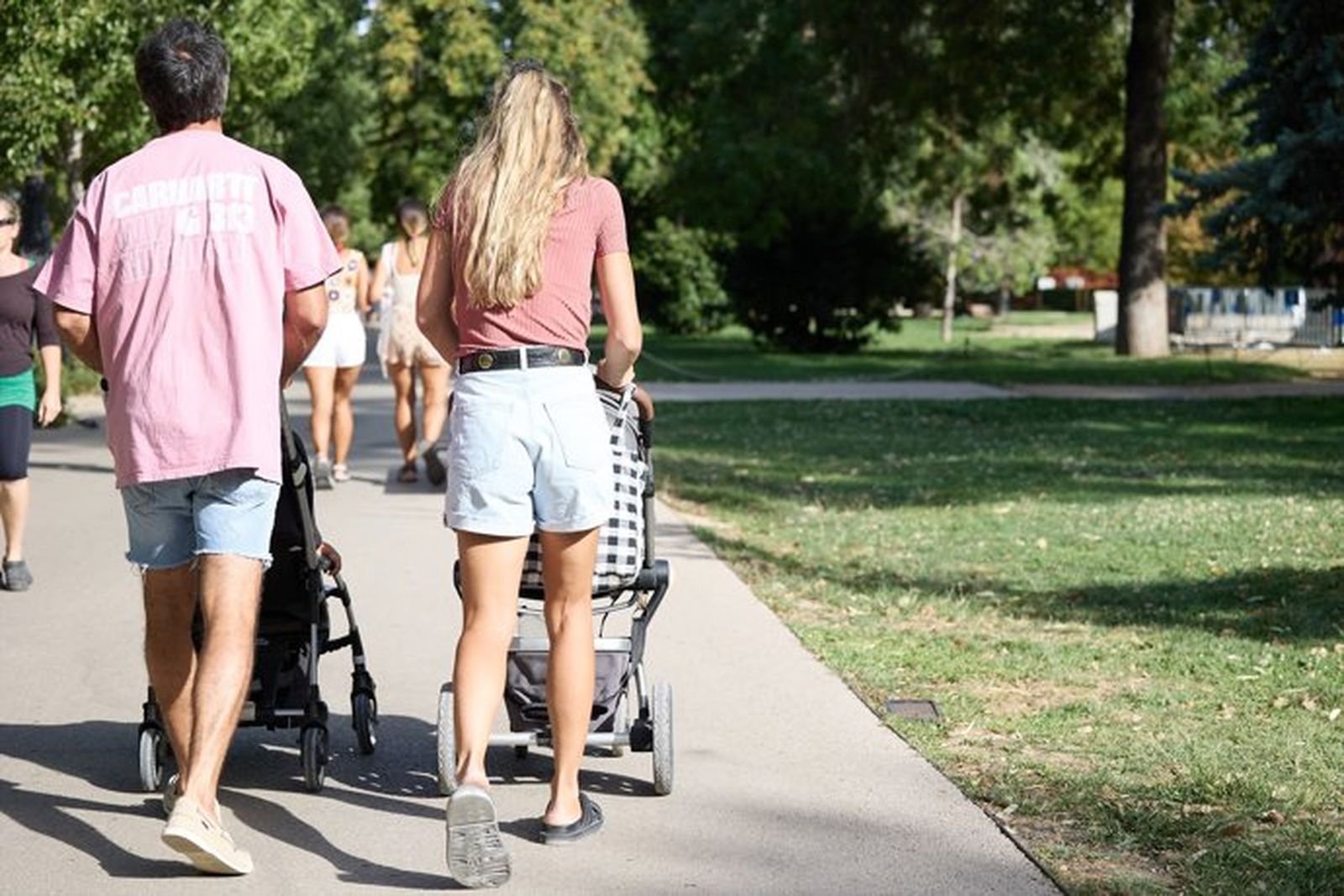 Una pareja pasea a dos bebés Una pareja pasea a dos bebés