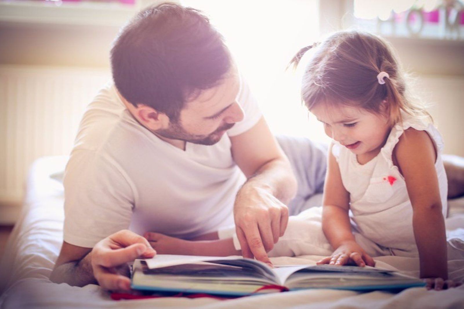 Niña con su padre leyendo un cuento. Foto Infosalus