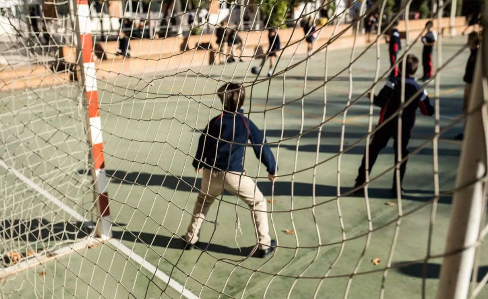 Niños juegan al fútbol en el patio de un colegio. EP
