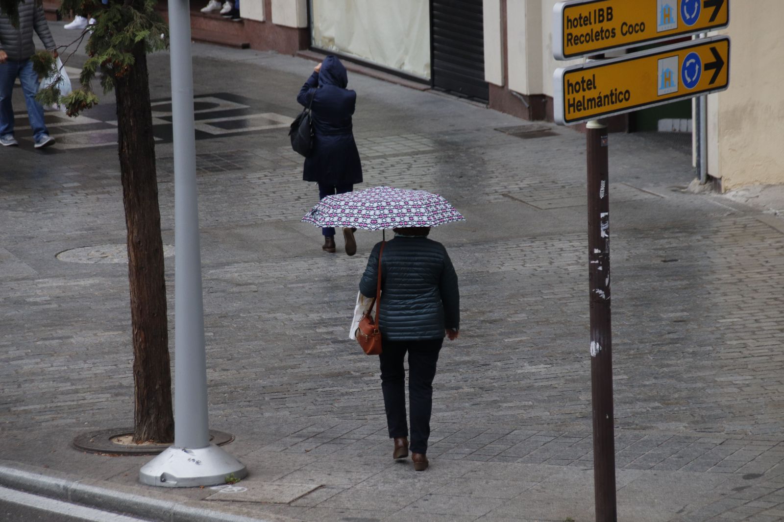 Gente paseando por las calles con paraguas