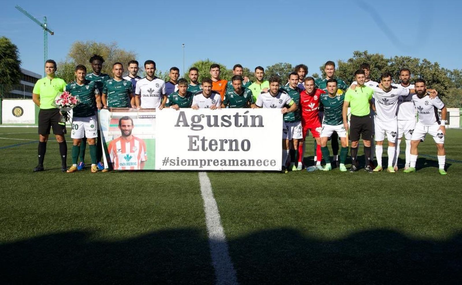 Los jugadores del Guijuelo y del Zamora posan con la pancarta en recuerdo de Agustín | FOTO CD GUIJUELO