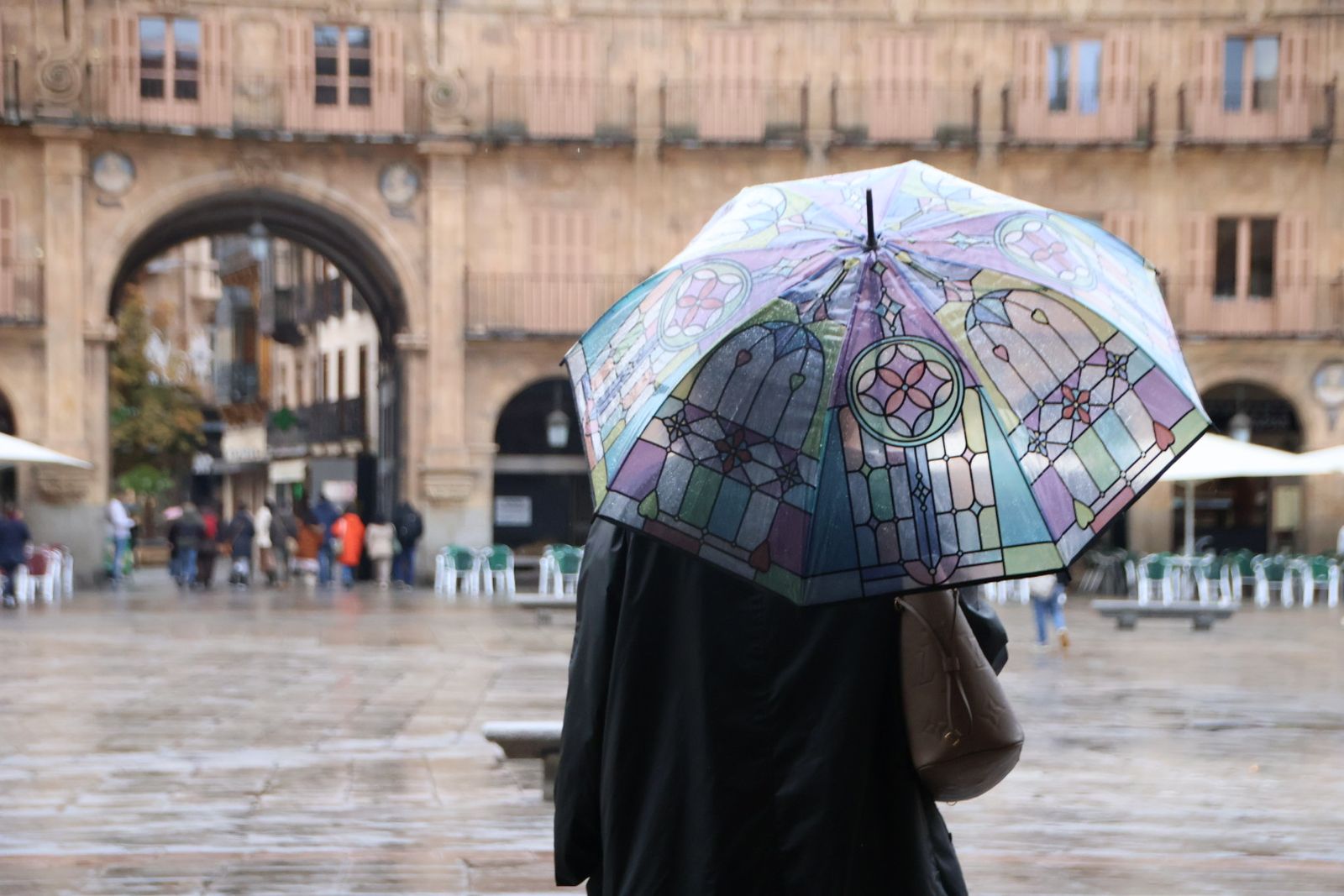 Mujer pasenado con paraguas en Salamanca
