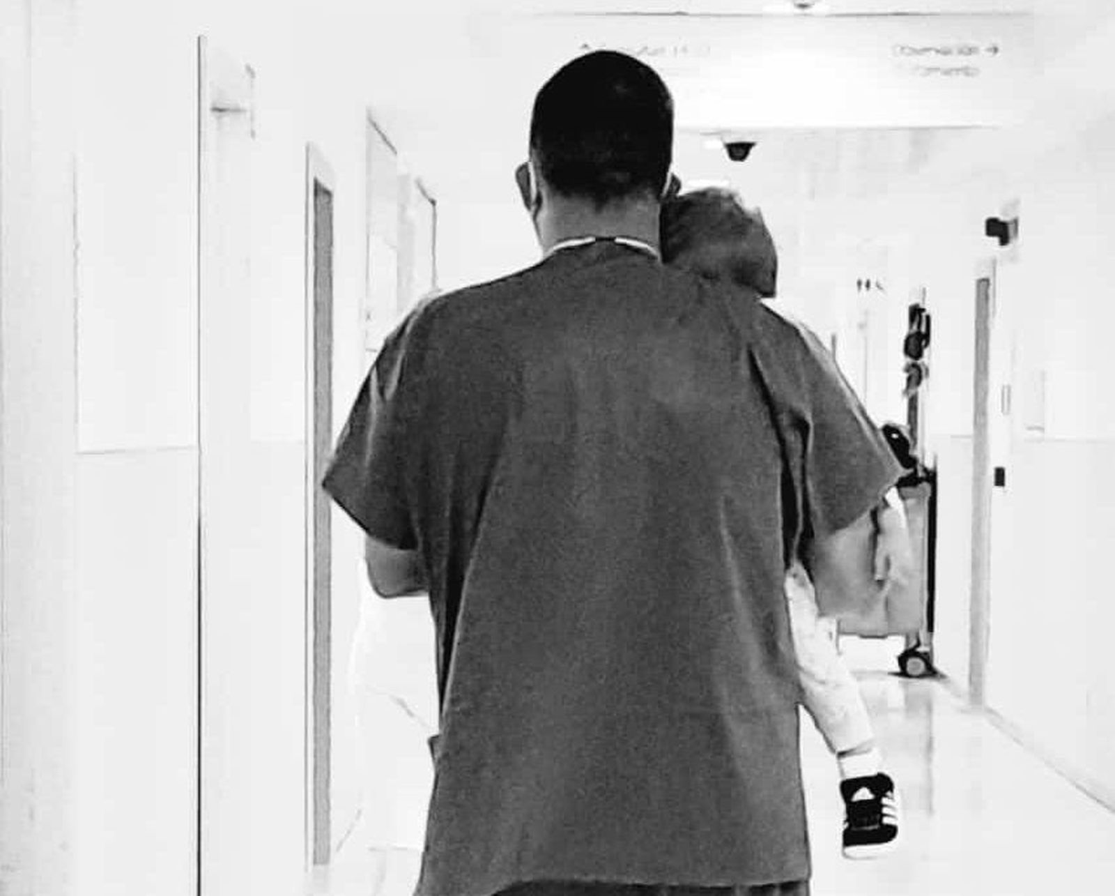 Imagen de un médico cogiendo en brazos a un niño de dos años en el hospital de Salamanca. Foto Ana G. Beneite