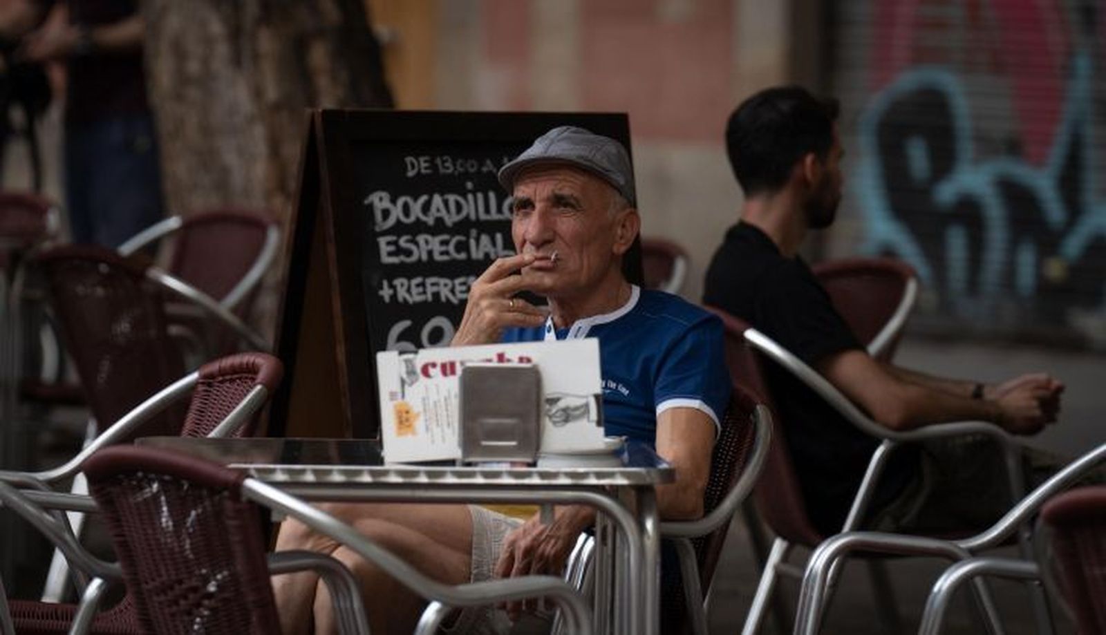 Un hombre fuma sentado en la mesa de una terraza | EP