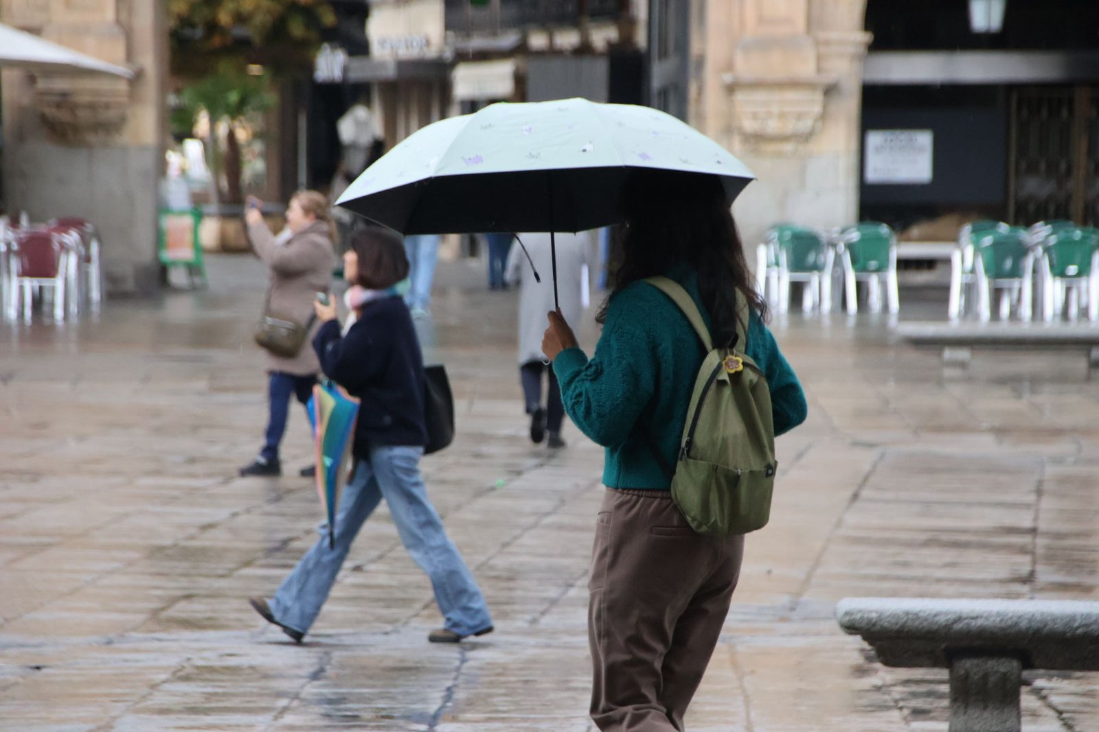Mujer pasenado con paraguas en Salamanca