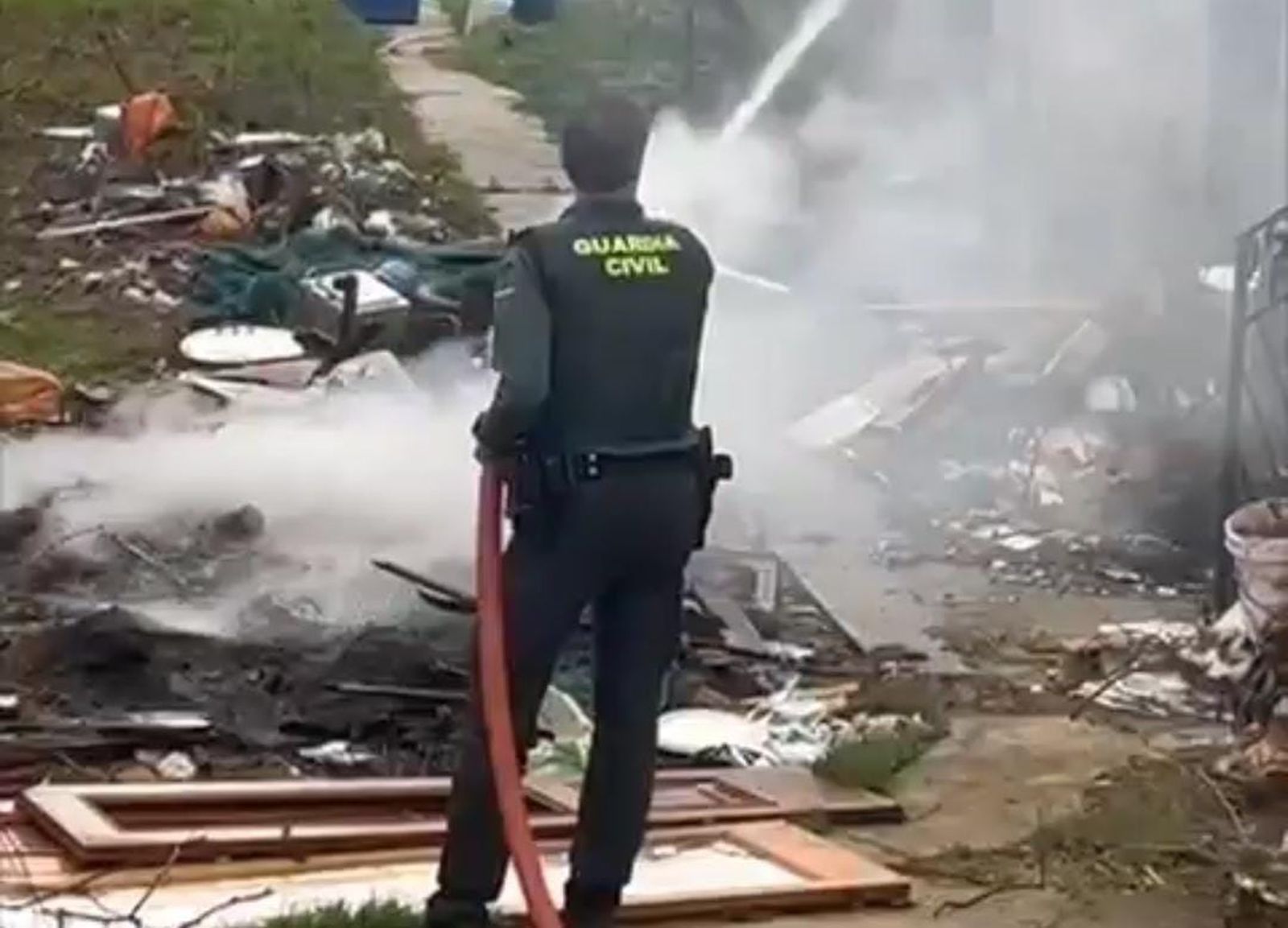 Un agente colabora en las tareas de extinción en el incendio de una vivienda en Villanueva de las Peras