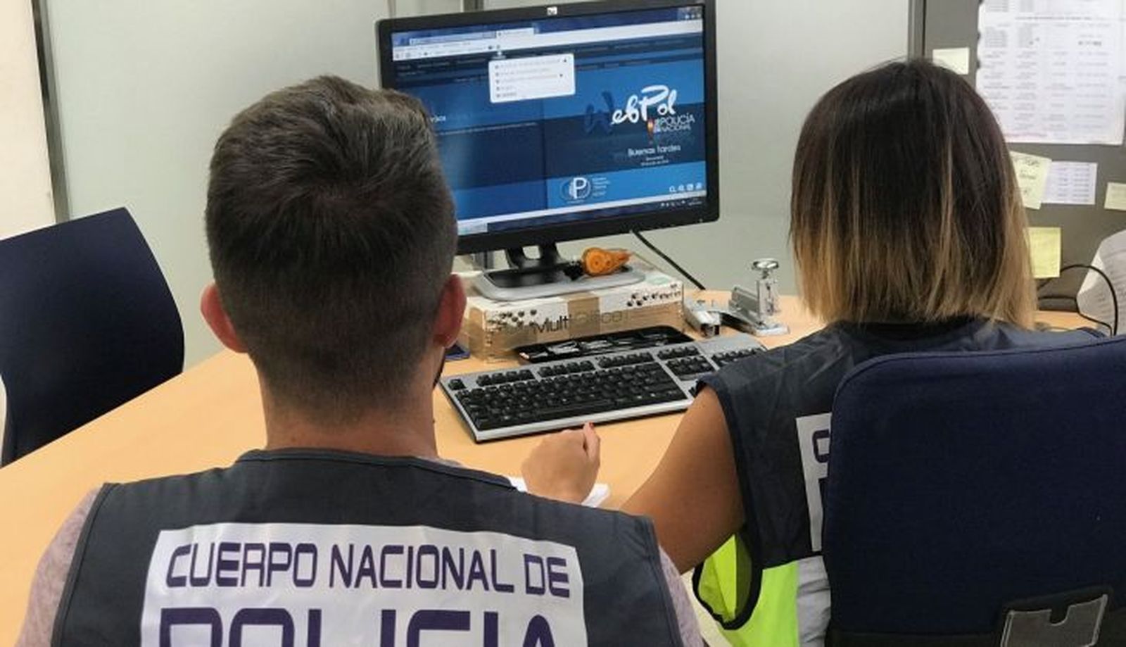  Agentes de la Policía Nacional delante de un ordenador 