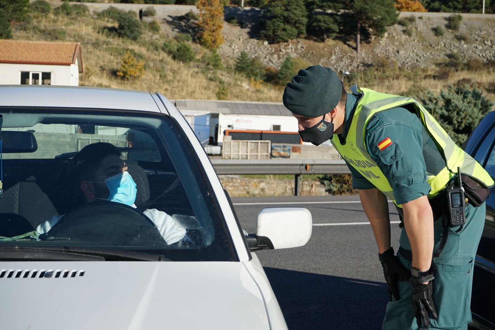 Un agente de la Guardia Civil le pide la documentación al conductor de un vehículo durante un control de movilidad en la carretera AP-6 de acceso a Segovia, Castilla y León, (España), a 30 de octu