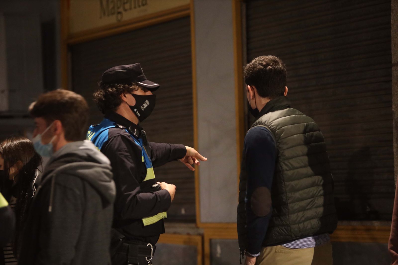 Un policía local de Salamanca habla con un joven.