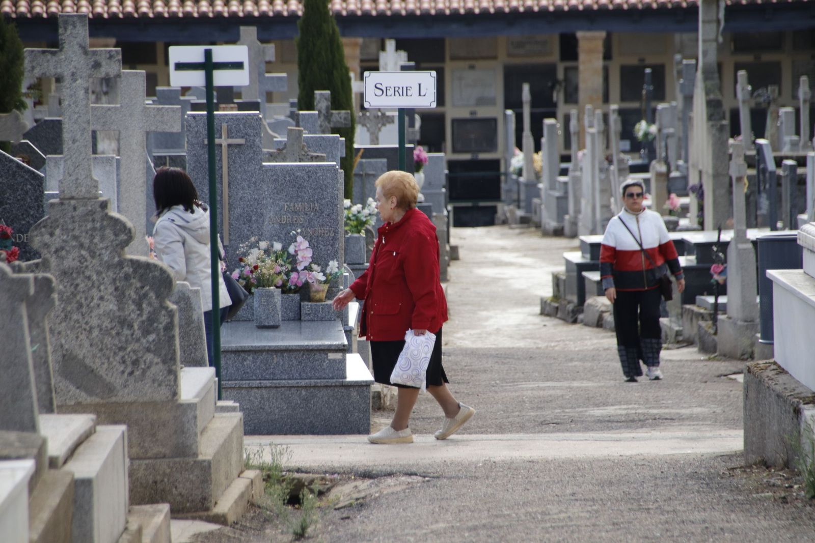Gente visitando a sus familiares en el cementerio