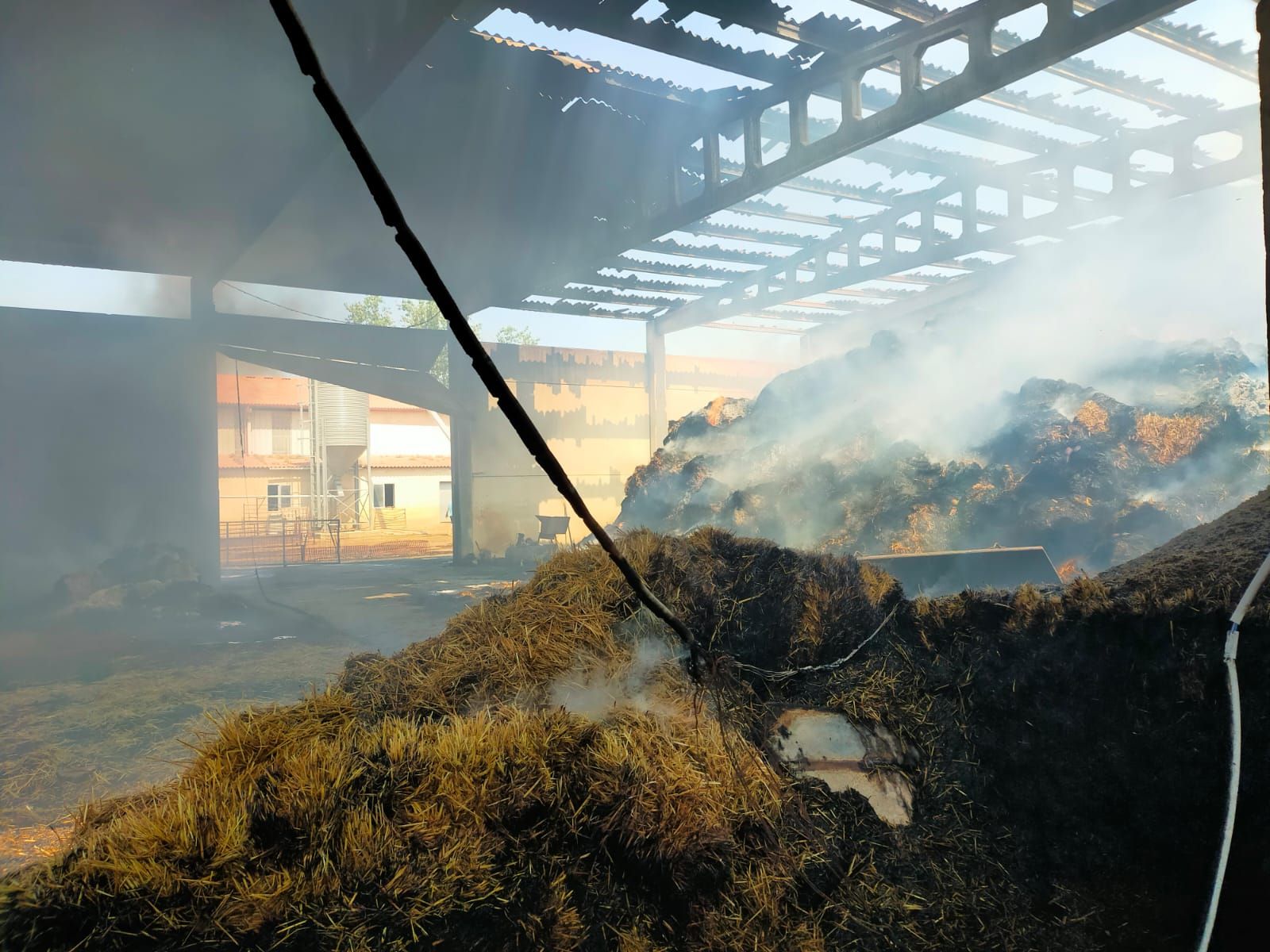 Continúan los trabajos de extinción y extracción tras el incendio de una nave ganadera en Monfarracinos