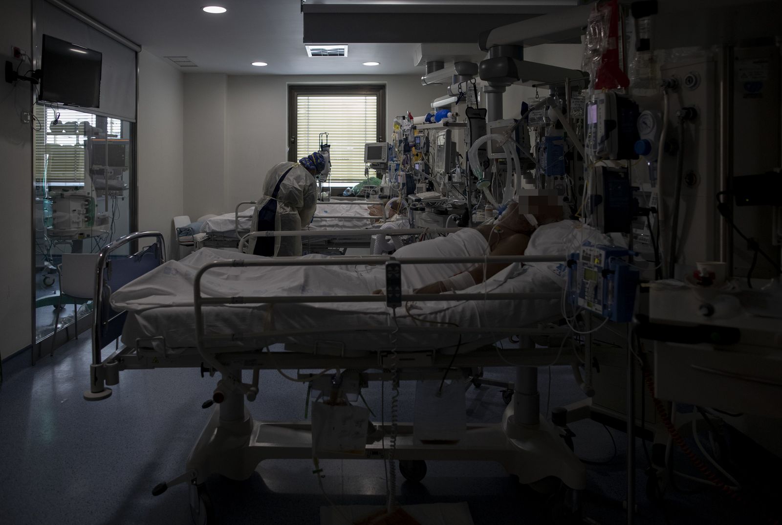 Una trabajadora de la limpieza durante su jornada laboral en la Unidad de Cuidados Intensivos (UCI) dedicada a enfermos de coronavirus del Hospital Universitario Ramón y Cajal, en Madrid (España)