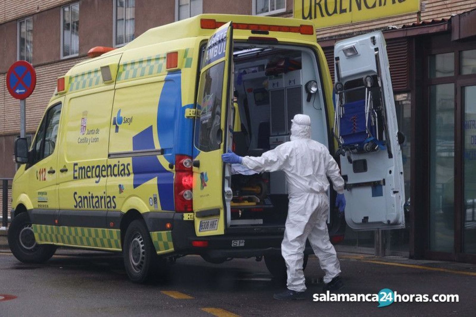 Un sanitario, protegido contra el COVID, se dispone a cerrar la ambulancia.