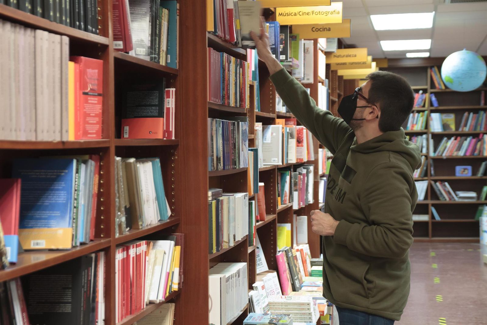 Un trabajador coloca libros en una librería Un trabajador coloca libros en una librería