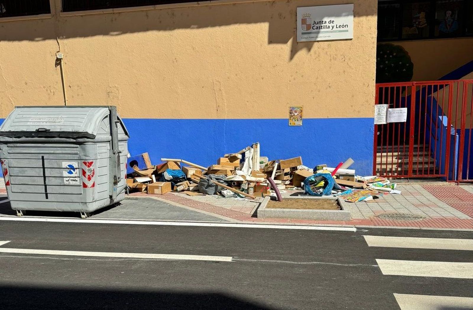 Restos de basura, cajas y cartones, acumulada a las puertas del CEIP Beatriz Galindo