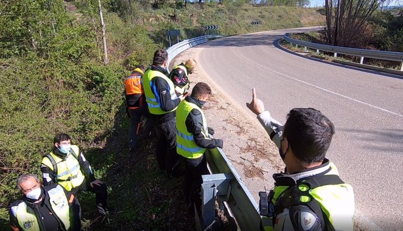 Varios motoristas intentar arreglar un guardarraíl en mal estado