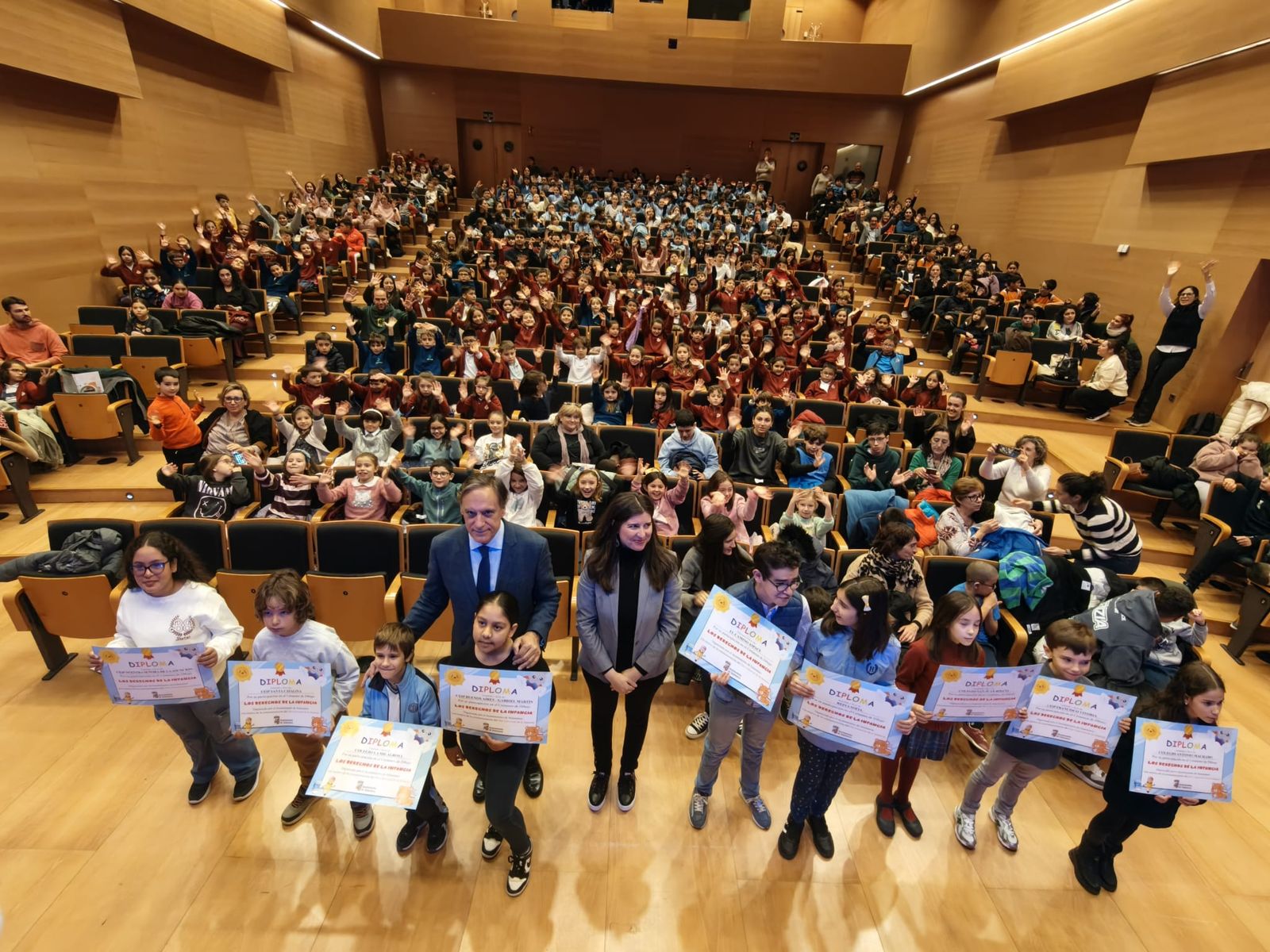 Los niños del concurso de dibujo de reciben sus diplomas premiados de las manos del alcalde por el Día Internacional de los Derechos de la Infancia
