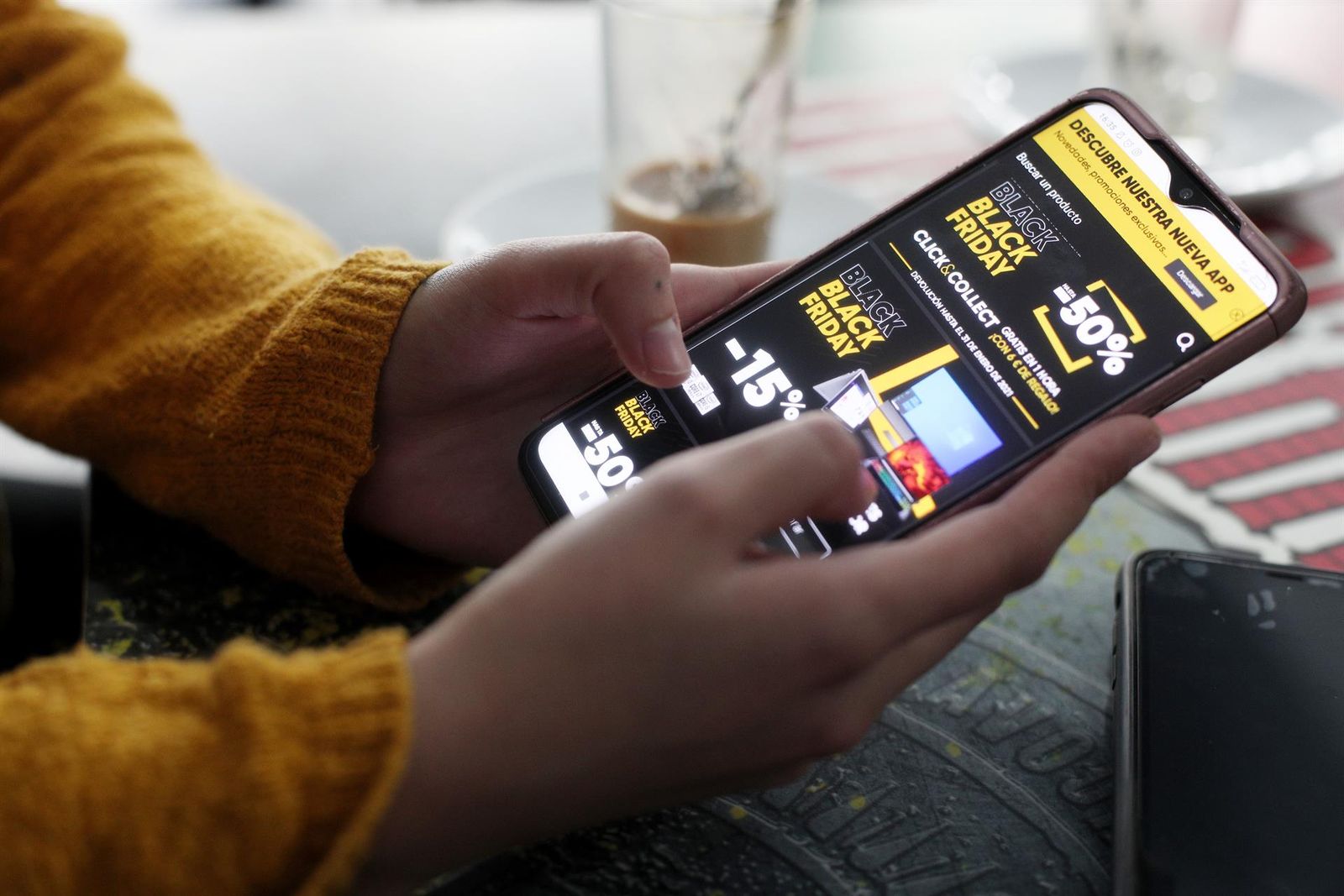 Una joven consulta las ofertas de Black Friday de un comercio en su móvil