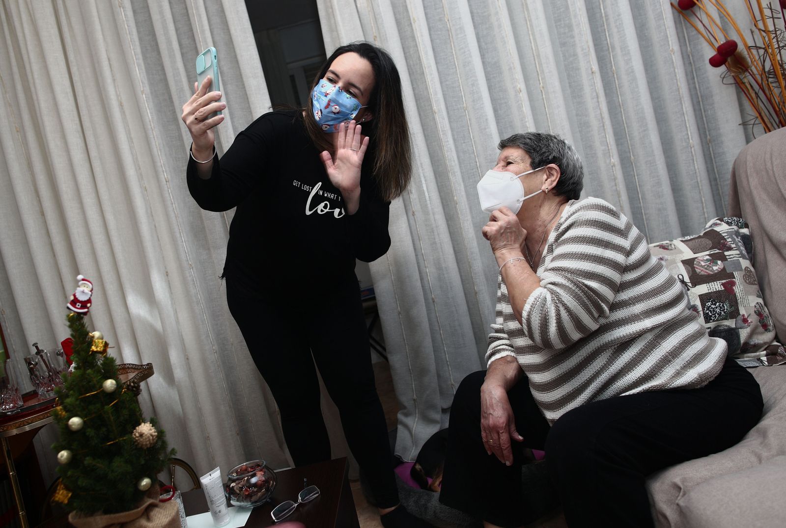 Una mujer viuda y de riesgo, Carmina y su hija Patricia hablan por videoconferencia con la hermana de Carmina en la cena de Nochebuena durante la pandemia en Móstoles (Madrid), a 24 de diciembre de 2