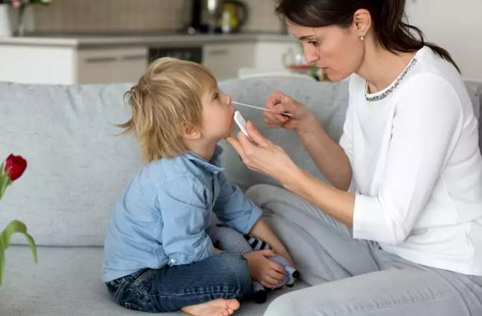 Madre realizando un test de antígenos a su hijo en casa | FOTO INFOSALUS EP