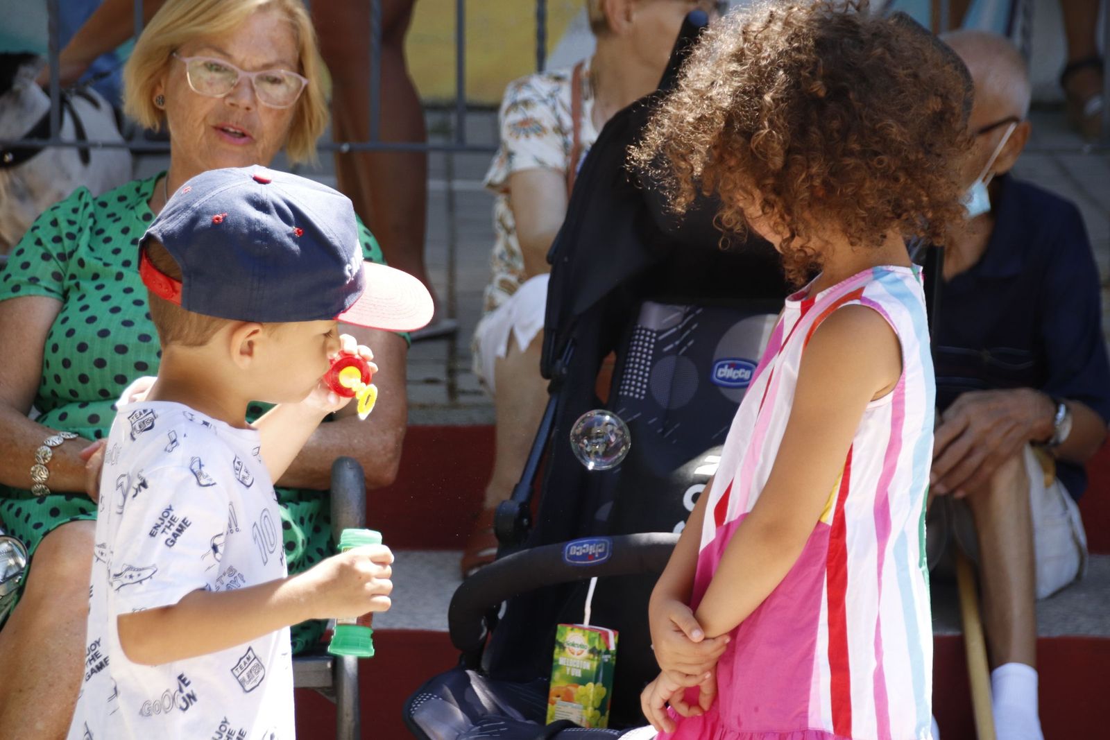 Gente en verano, calor, niño haciendo burbujas
