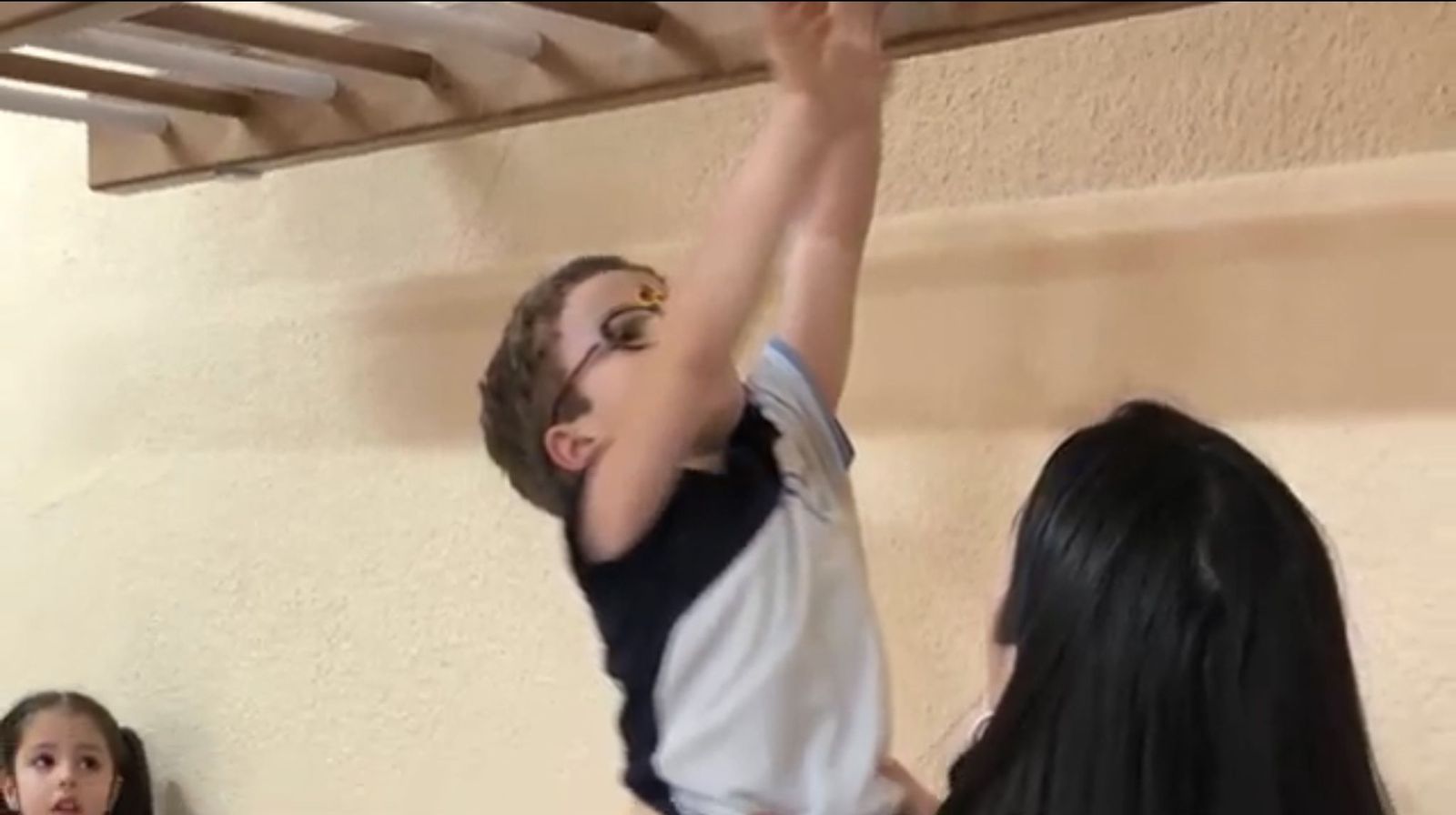 Una profesora supervisa a un joven alumno